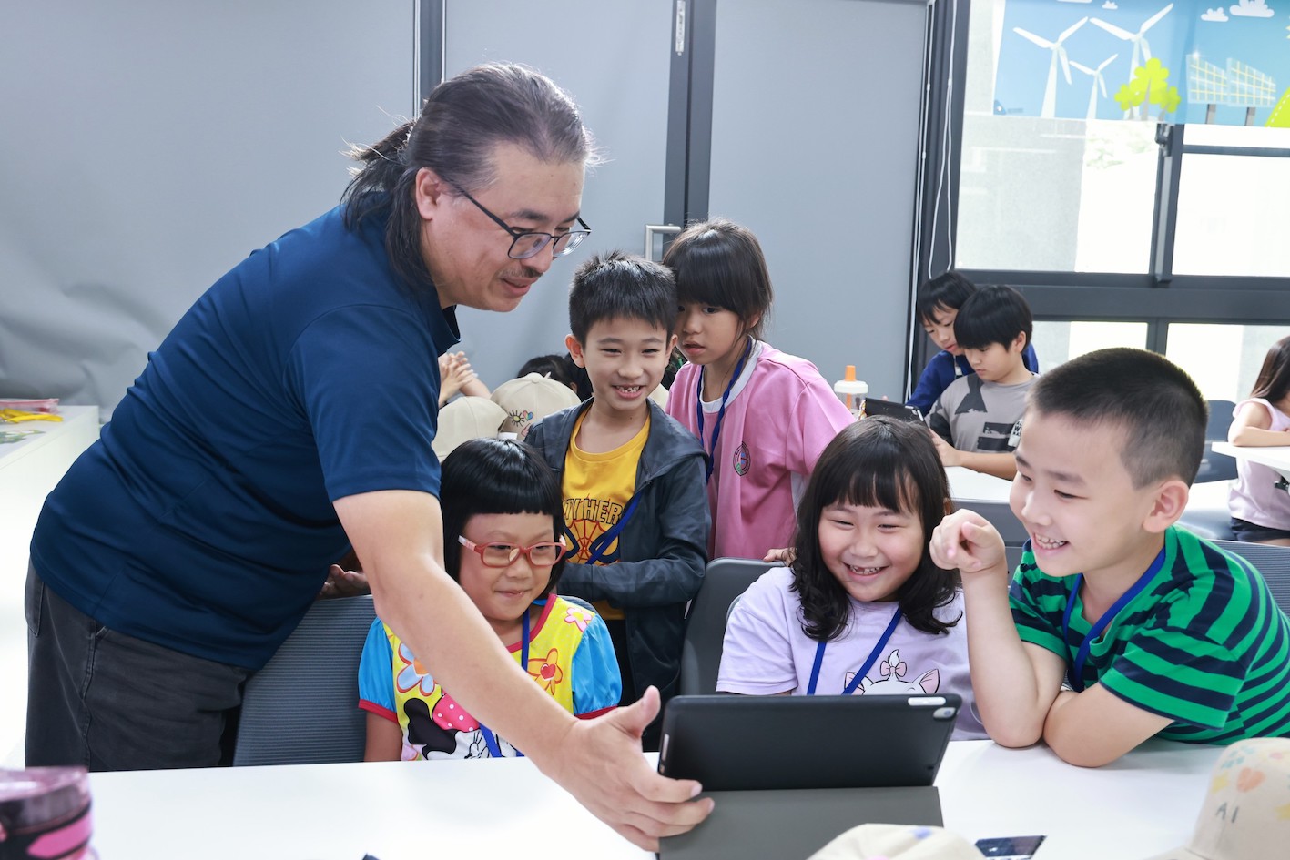 臺中市大明國民小學教師張威端帶領學童實際操作 AI。(圖/臺南市政府)