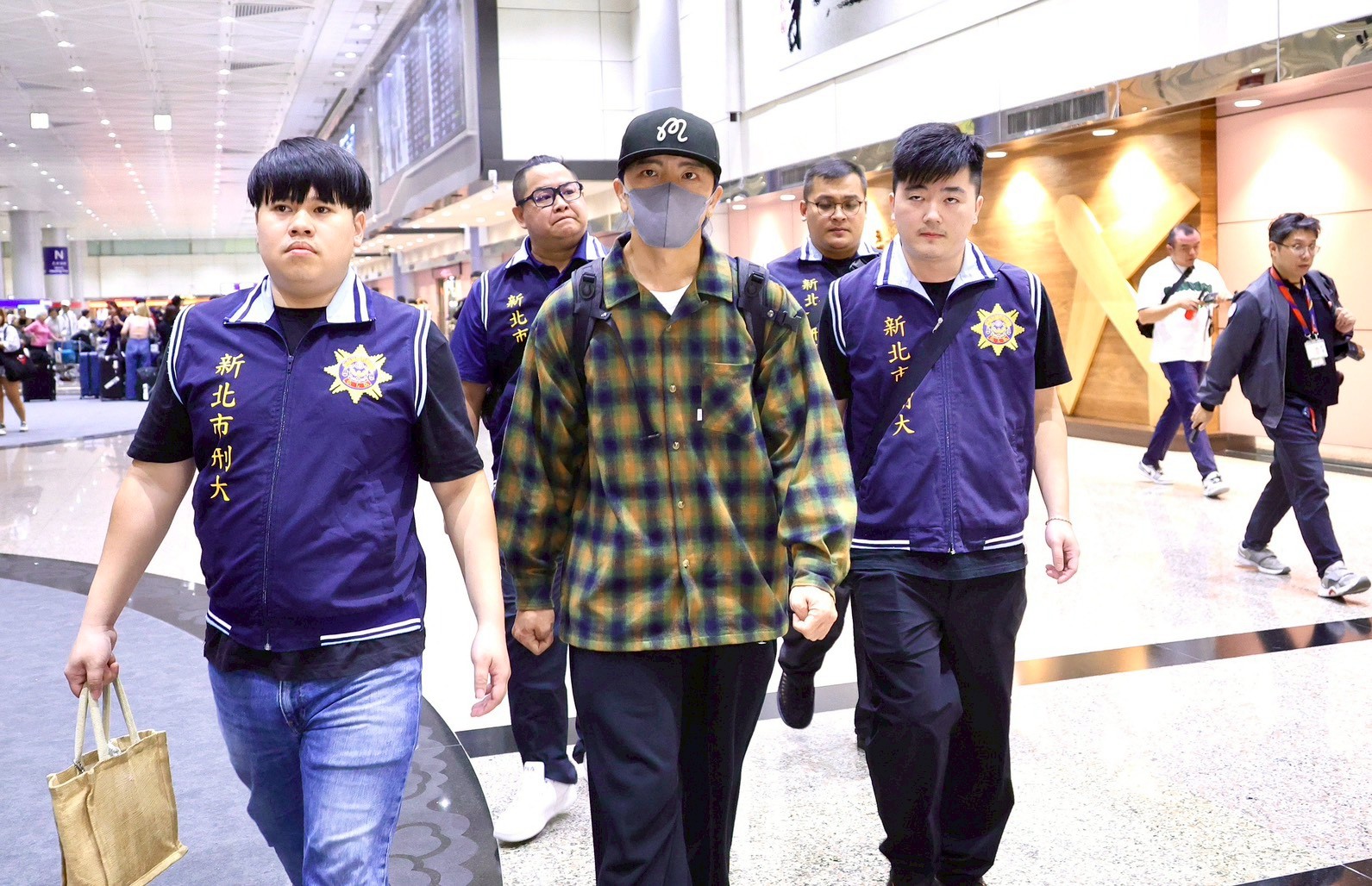 坤達(中)一回國就被檢警帶走。(圖/娛樂中心攝)