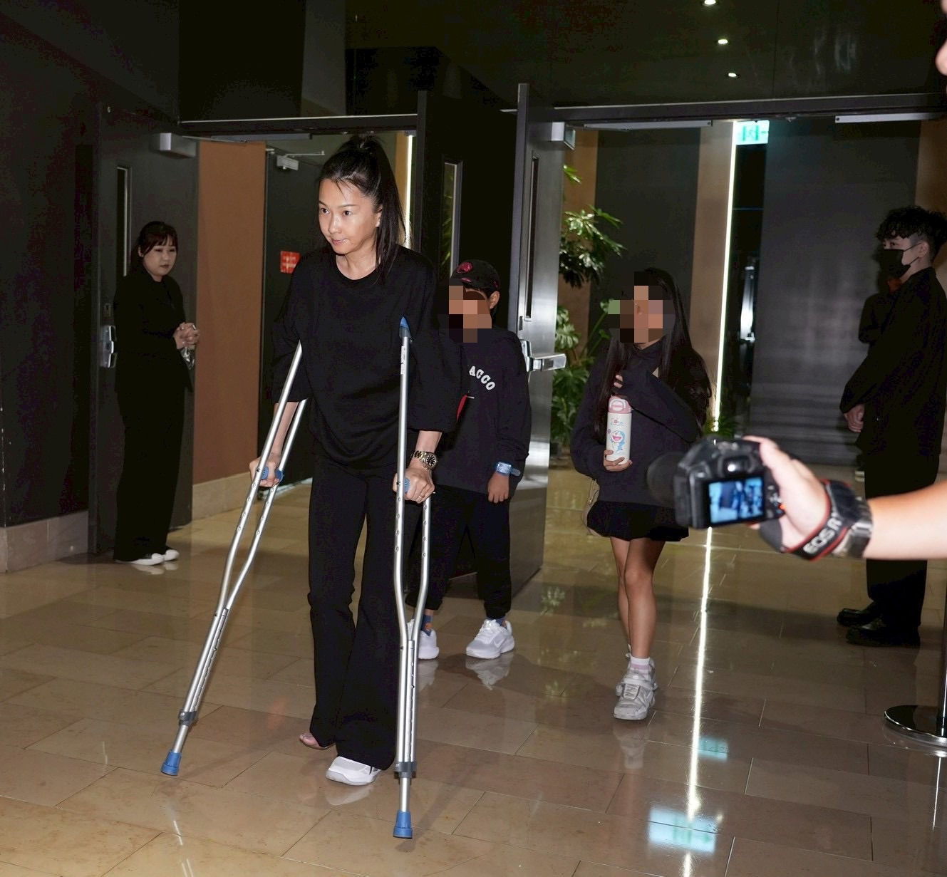杵著拐杖的六月帶著一雙兒女到場。(圖/記者許方正攝)