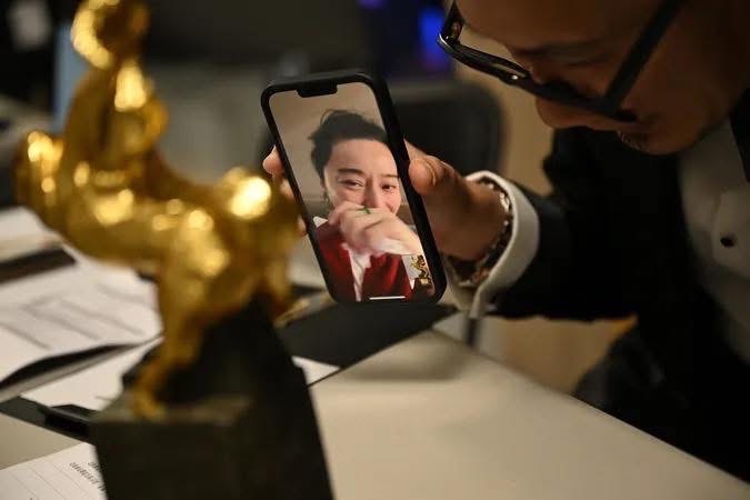 導演張吉安到典禮後台和幫范冰冰視訊看獎座。（圖／金馬獎官方攝影師李開明拍攝）
