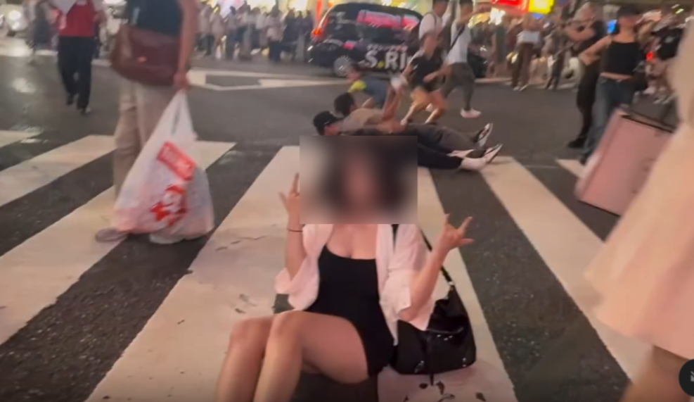 台灣女子在人潮湧現的澀谷馬路坐地擺拍。（圖／翻攝Threads）