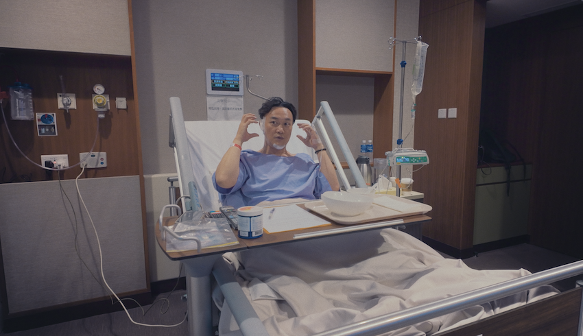陳奕迅在演唱會紀錄電影中，曝光自己身躺醫院，臉上包滿紗布畫面。（圖／廿一克有限公司提供）