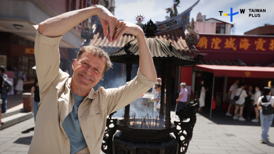 尼爾斯歐勒在台北霞海城隍廟見證青年男女祈求月老賜姻緣的文化。（圖／TaiwanPlus提供）