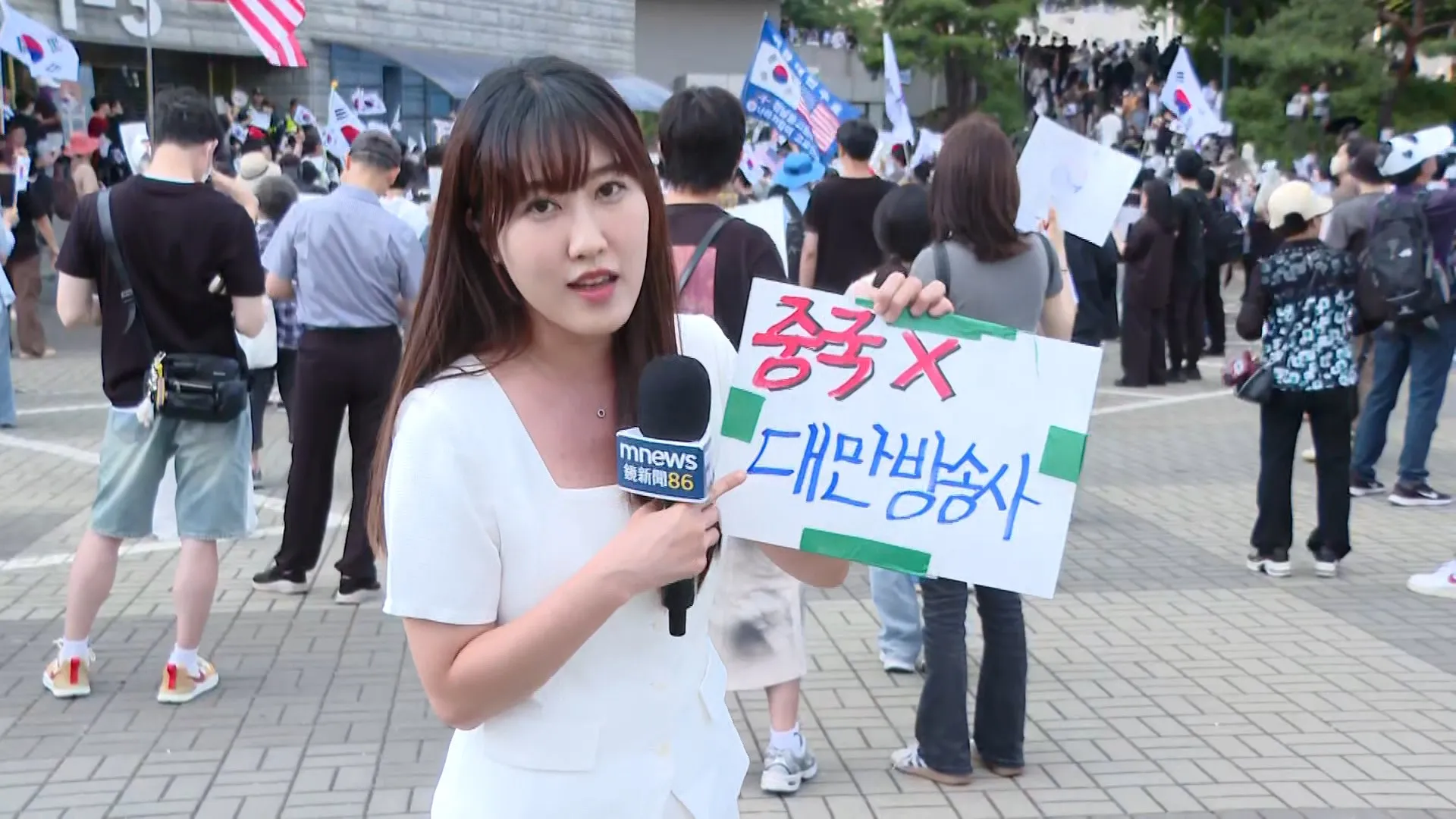 鏡新聞主播張倍滋表明來自台灣後,獲熱心民眾在背後張貼韓文告示應援,甚至引來韓國媒體爭相報導。(圖/鏡新聞提供)
