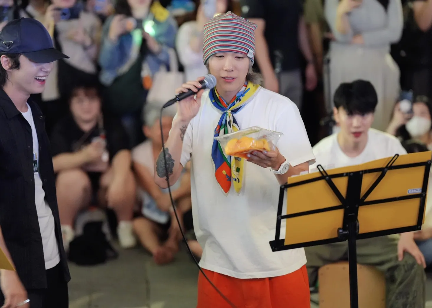FTISLAND主唱李洪基接下粉絲切好的芒果。(圖/記者陳明中攝)