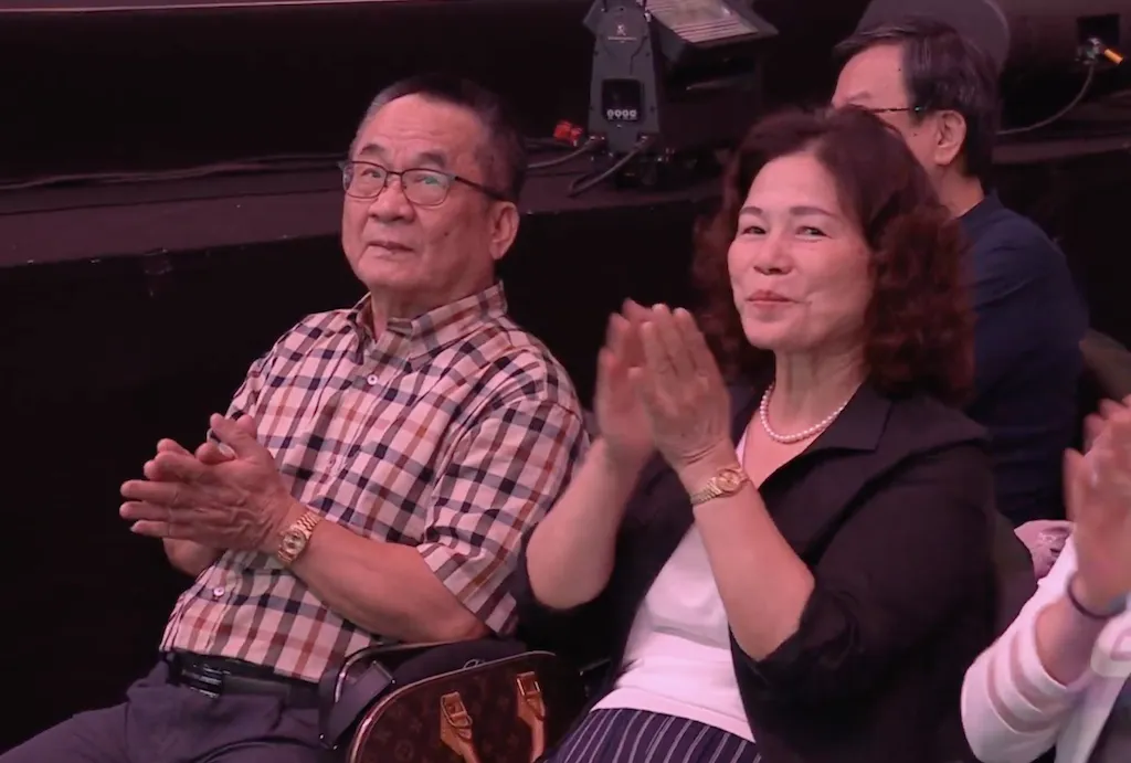 孫爸（左）和孫媽在台下觀賞女兒演出。（圖／翻攝影片）
