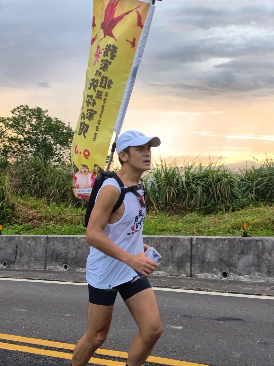 導演蘇達背電影《怎麼可能我家的祖先是你家的鬼》旗幟「跑」宣傳，沿路追輕軌還被誤認選立委。（圖／華映提供）