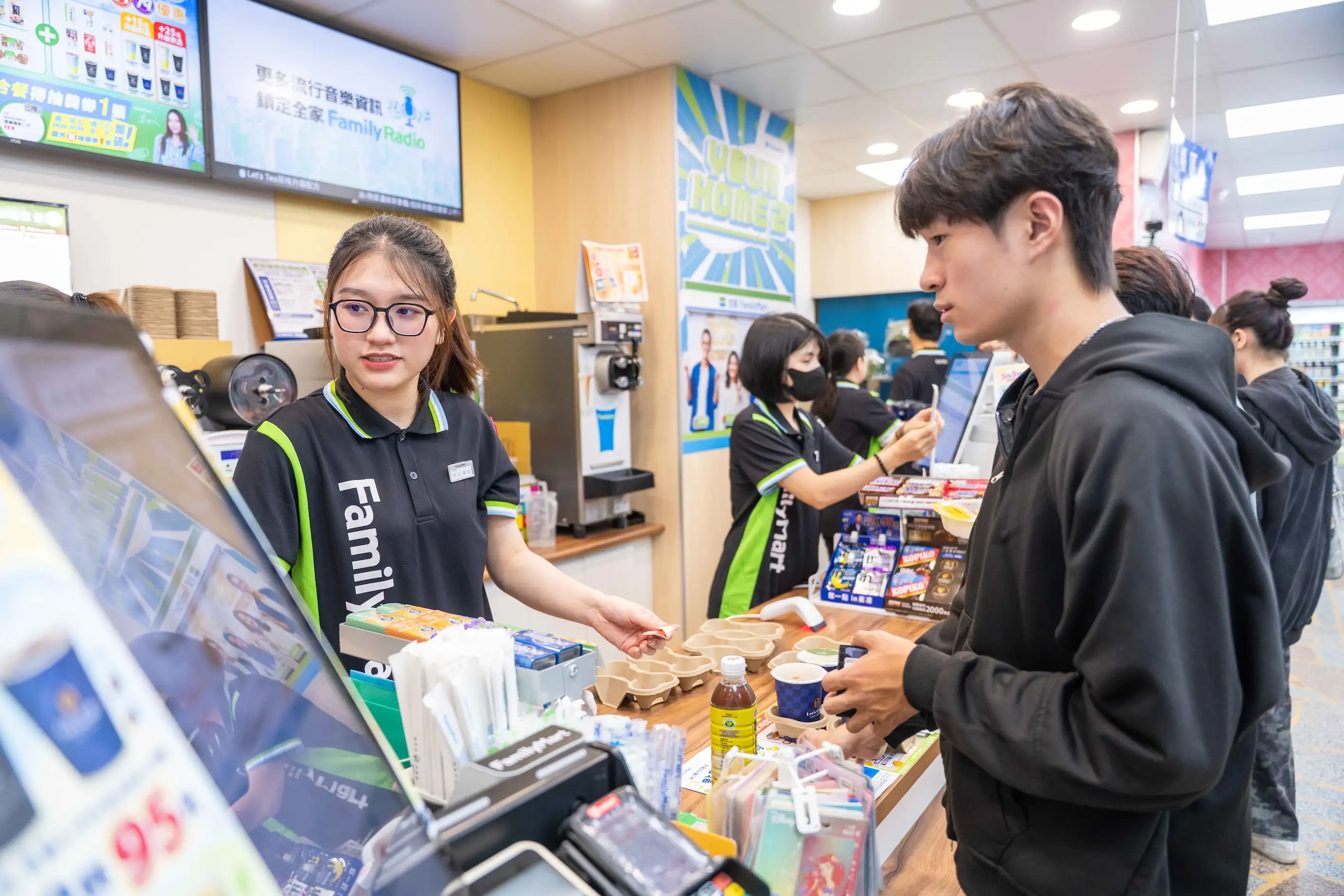 全家便利商店「林口醒大店」開幕後立即湧入師生採購,店舖人員忙著結帳、提供服務;逾百款東南亞商品與多語友善設施,讓便利服務真正融入醒吾科大師生日常生活。(圖/全家提供)